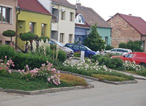 Předzahrádky u domů na hlavní ulici s vjezdy